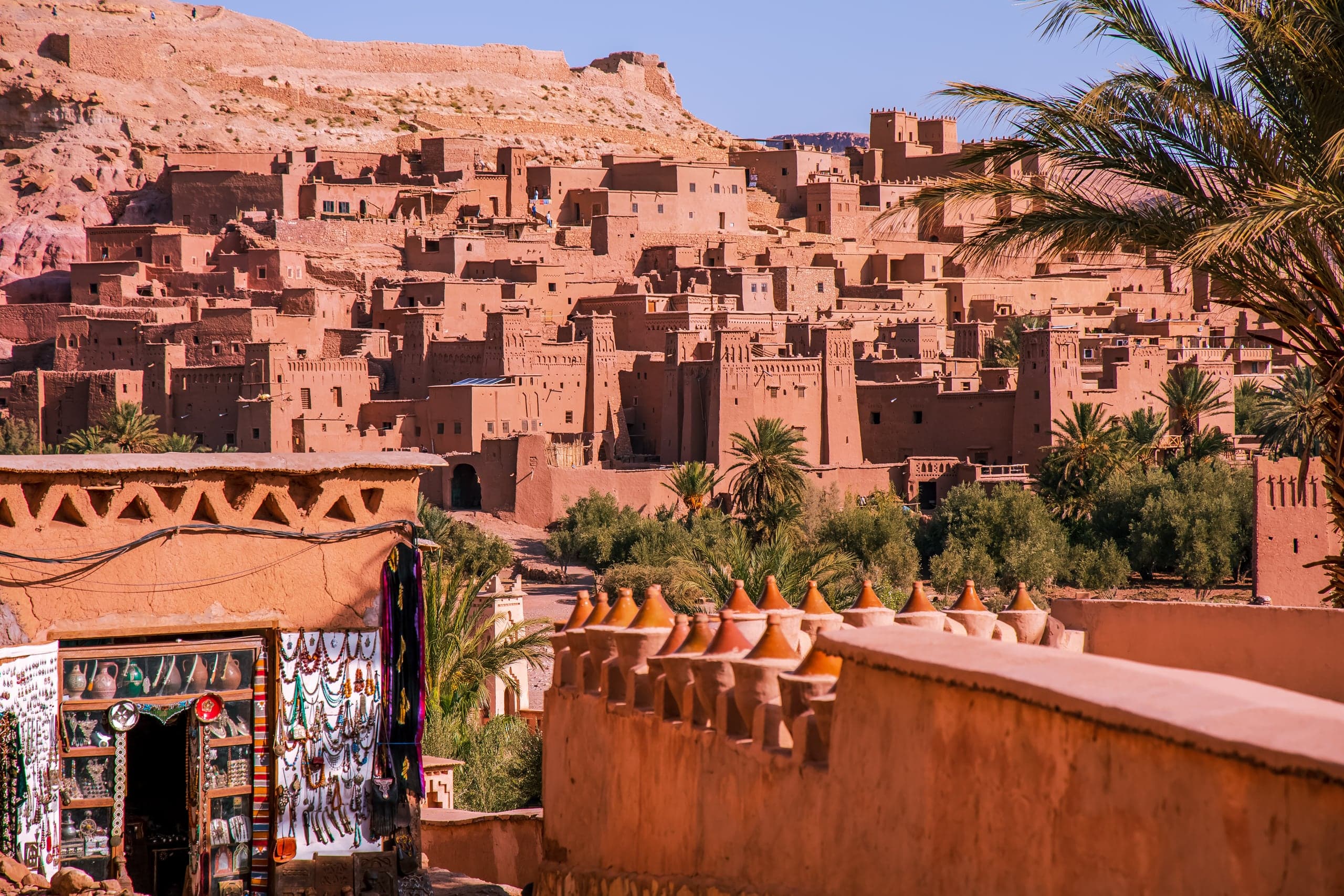 A craft stall on a terrace below the red towers of Aït Benhaddou