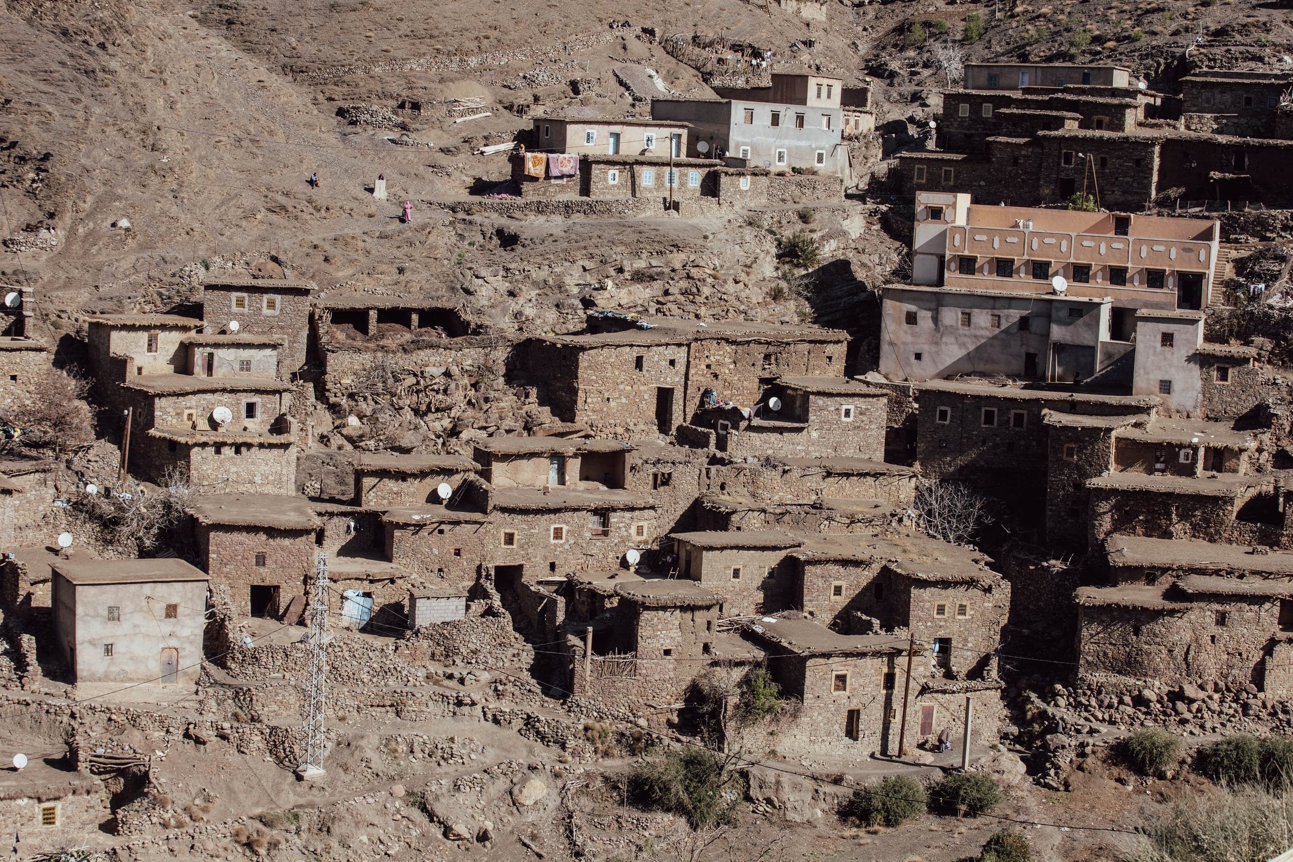Stone and earth houses stepped up a hillside in a High Atlas village