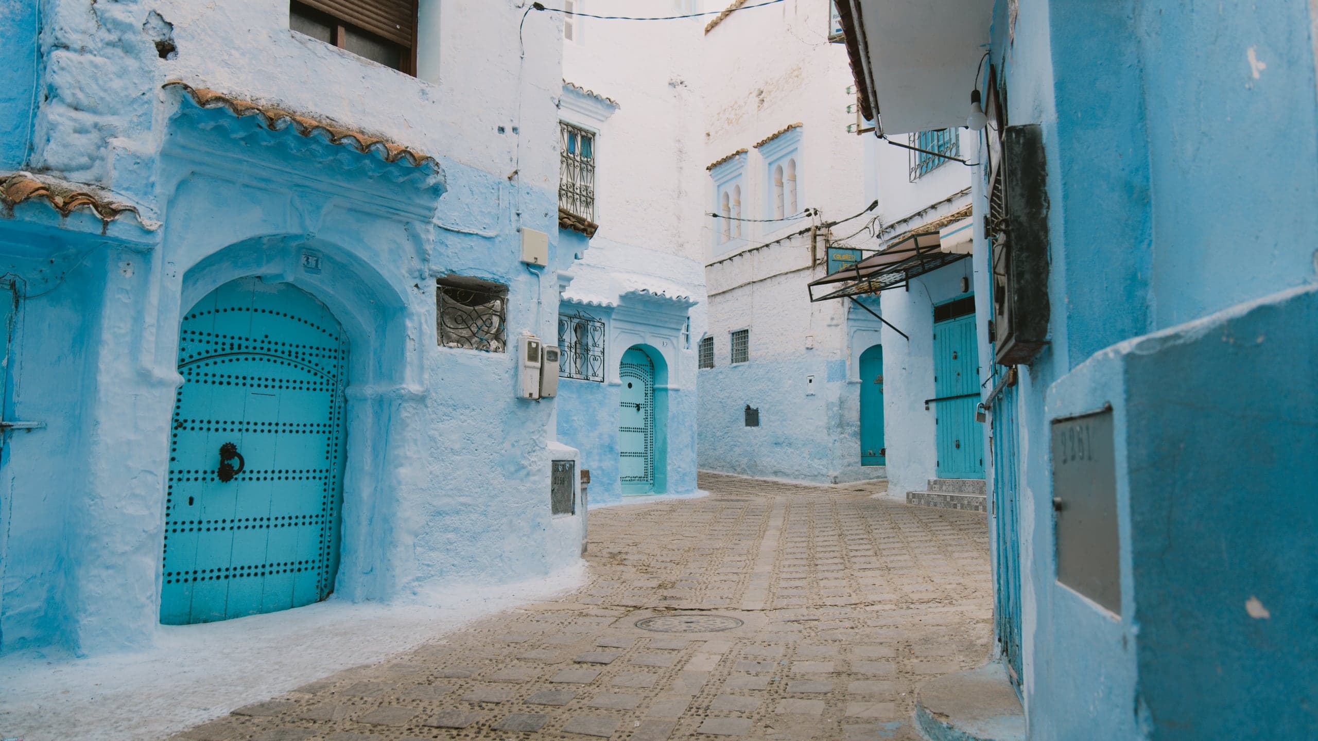 A sky-blue lane with studded doors in Chefchaouen