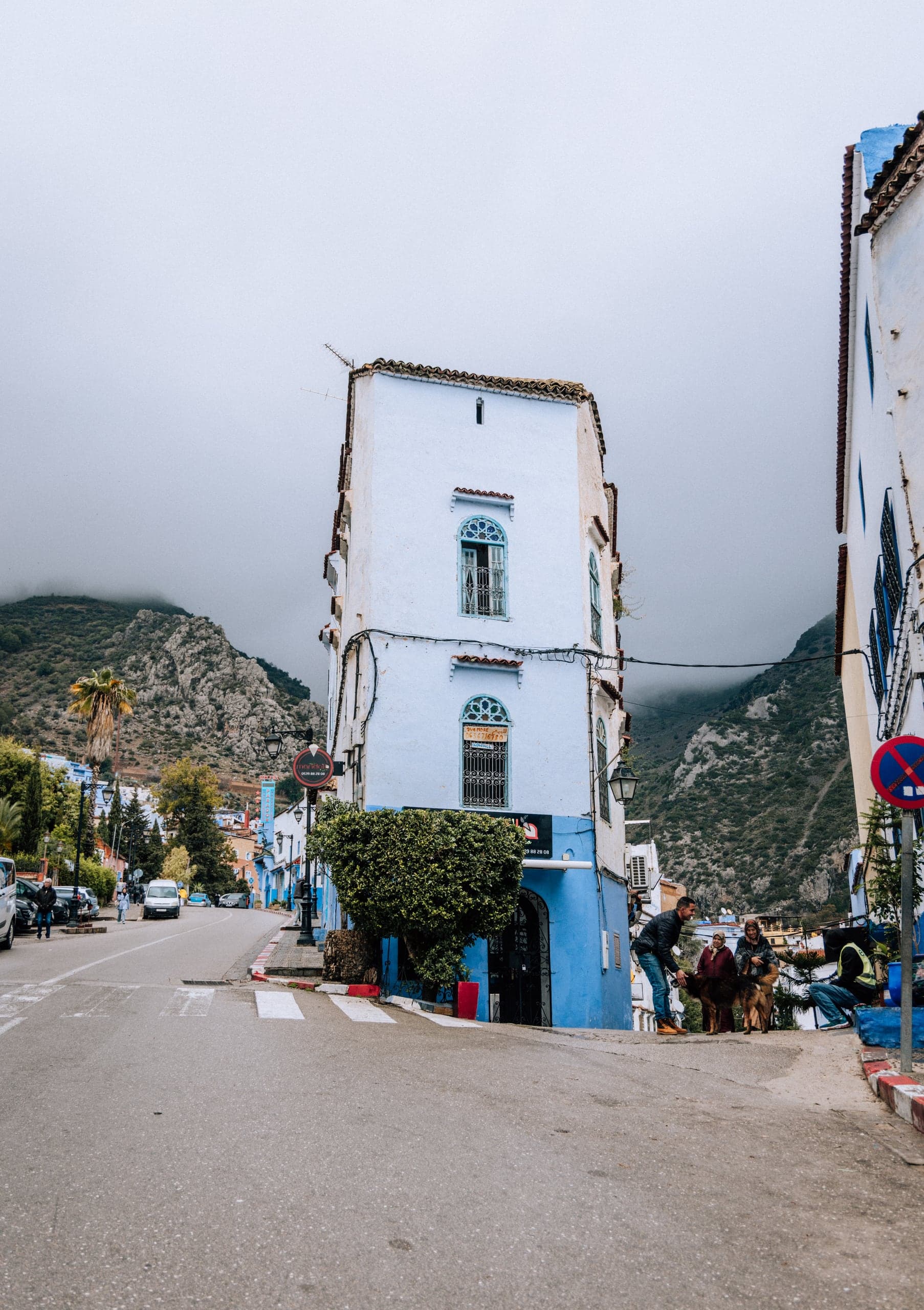 A blue-trimmed corner house at a junction in Chefchaouen