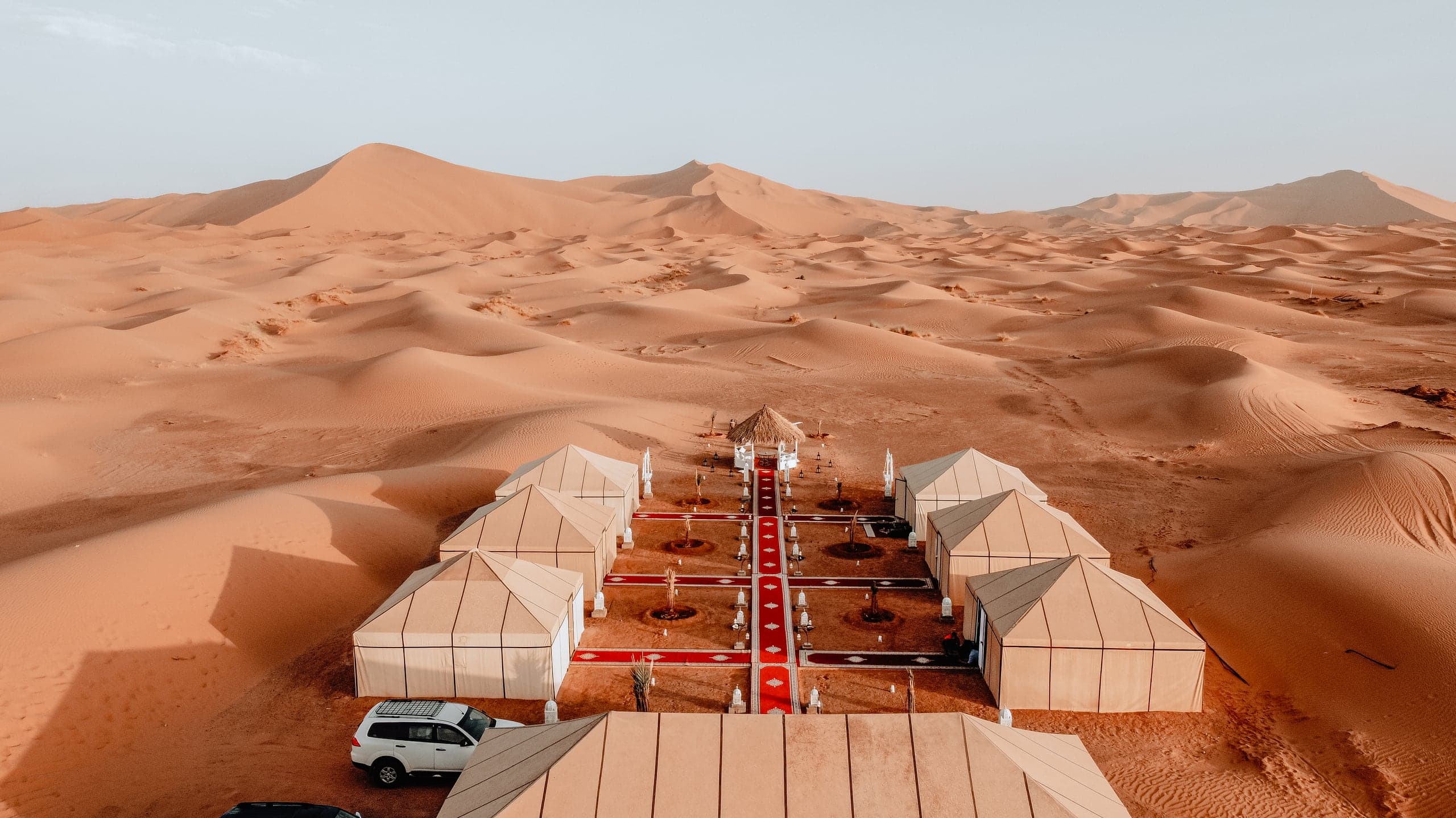 White tents of a desert camp set among the dunes of Erg Chebbi