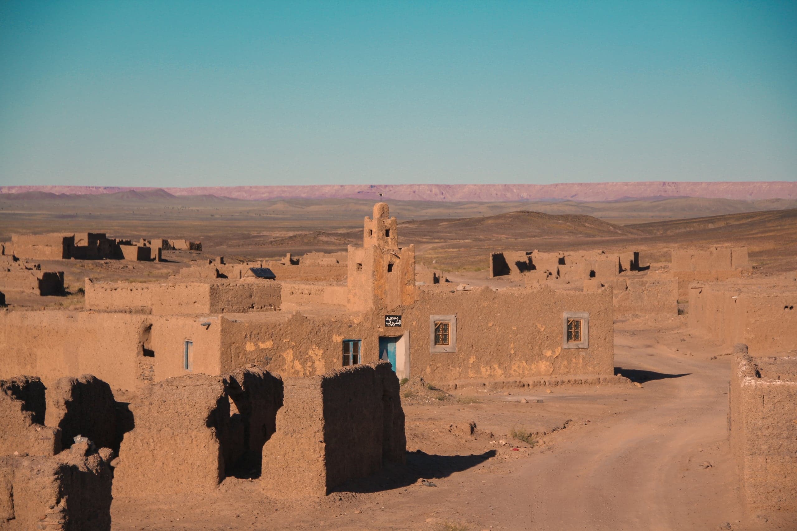 Ruined earthen walls of a ksar glowing in low sun, Draa Valley
