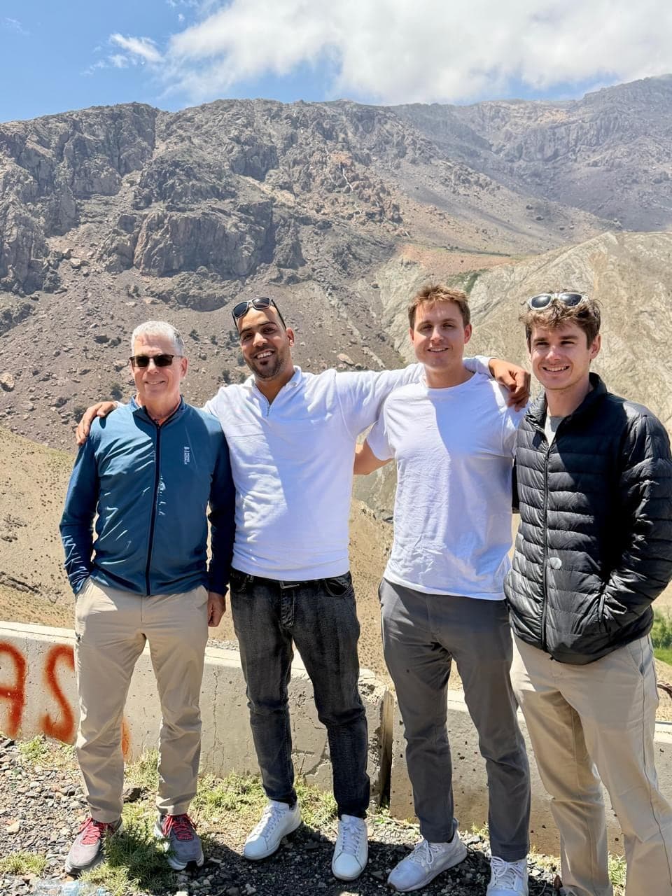 Our driver arm in arm with three travellers at a lookout in the High Atlas