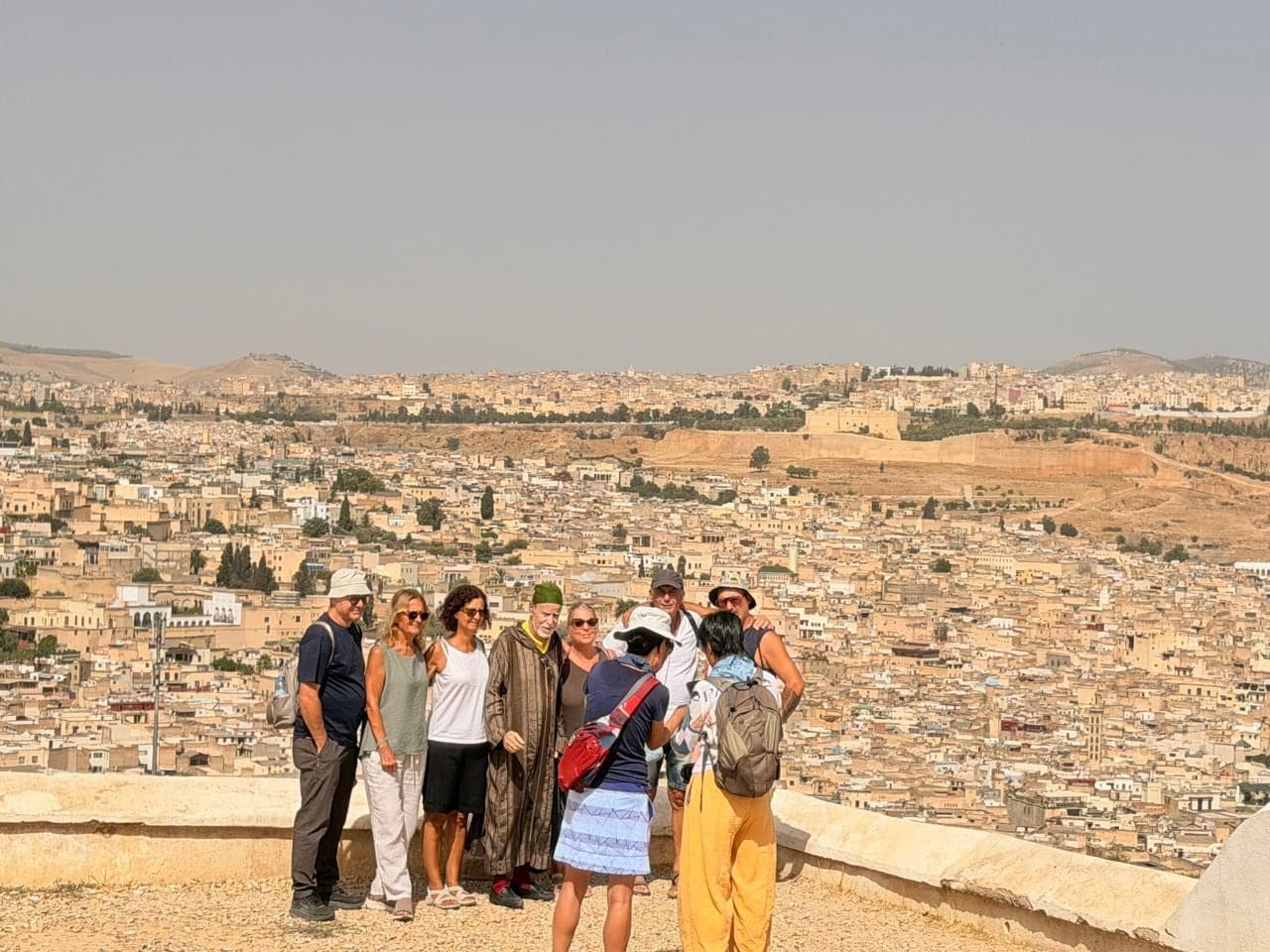 A group of travellers posing above the rooftops of the Fes medina