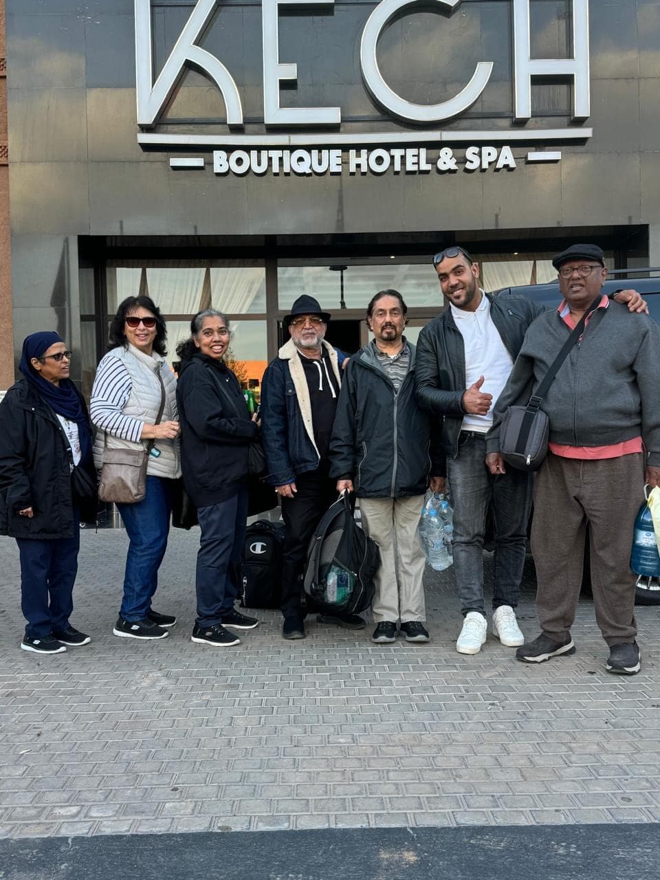 Our driver with a group of guests outside their Marrakech hotel, bags in hand