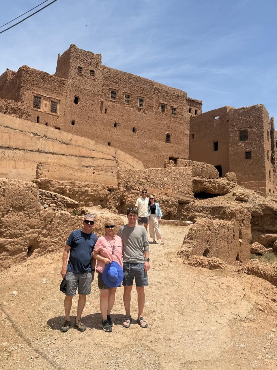 A family of travellers below the earthen walls of an old kasbah