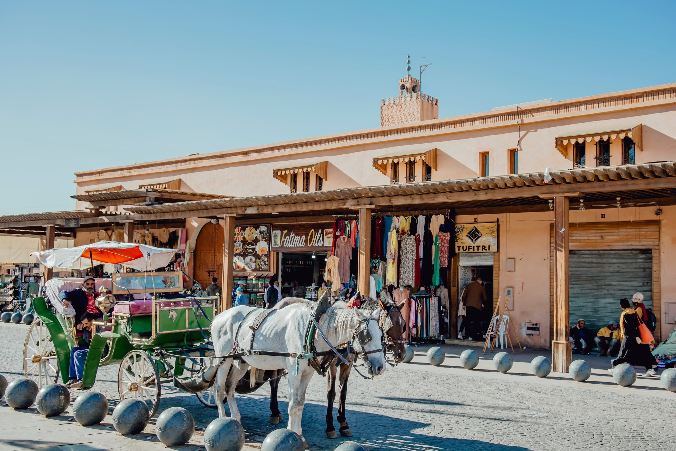 A horse-drawn calèche waiting outside shops in Marrakech