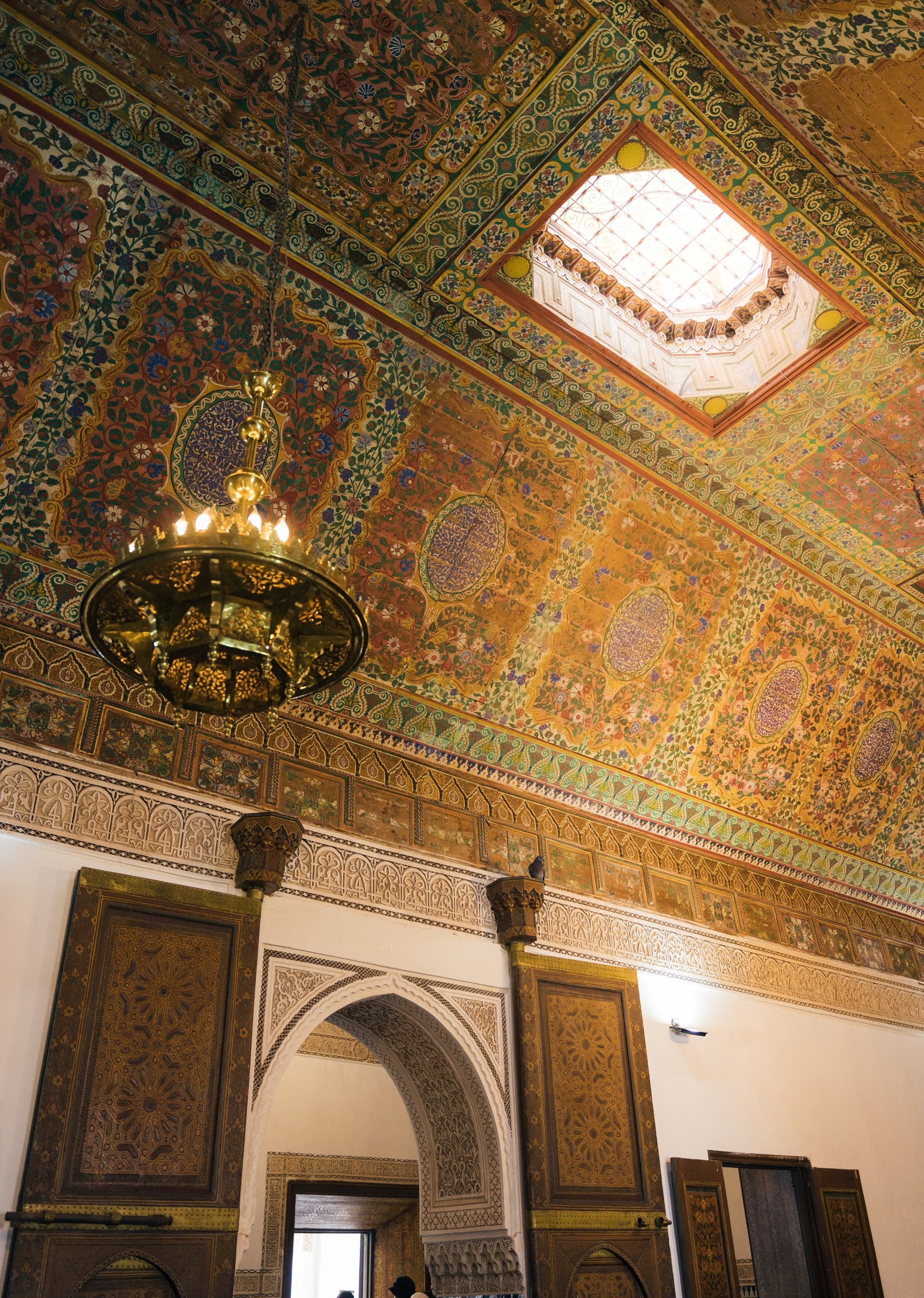 A gilded, hand-painted ceiling and chandelier in a Marrakech palace