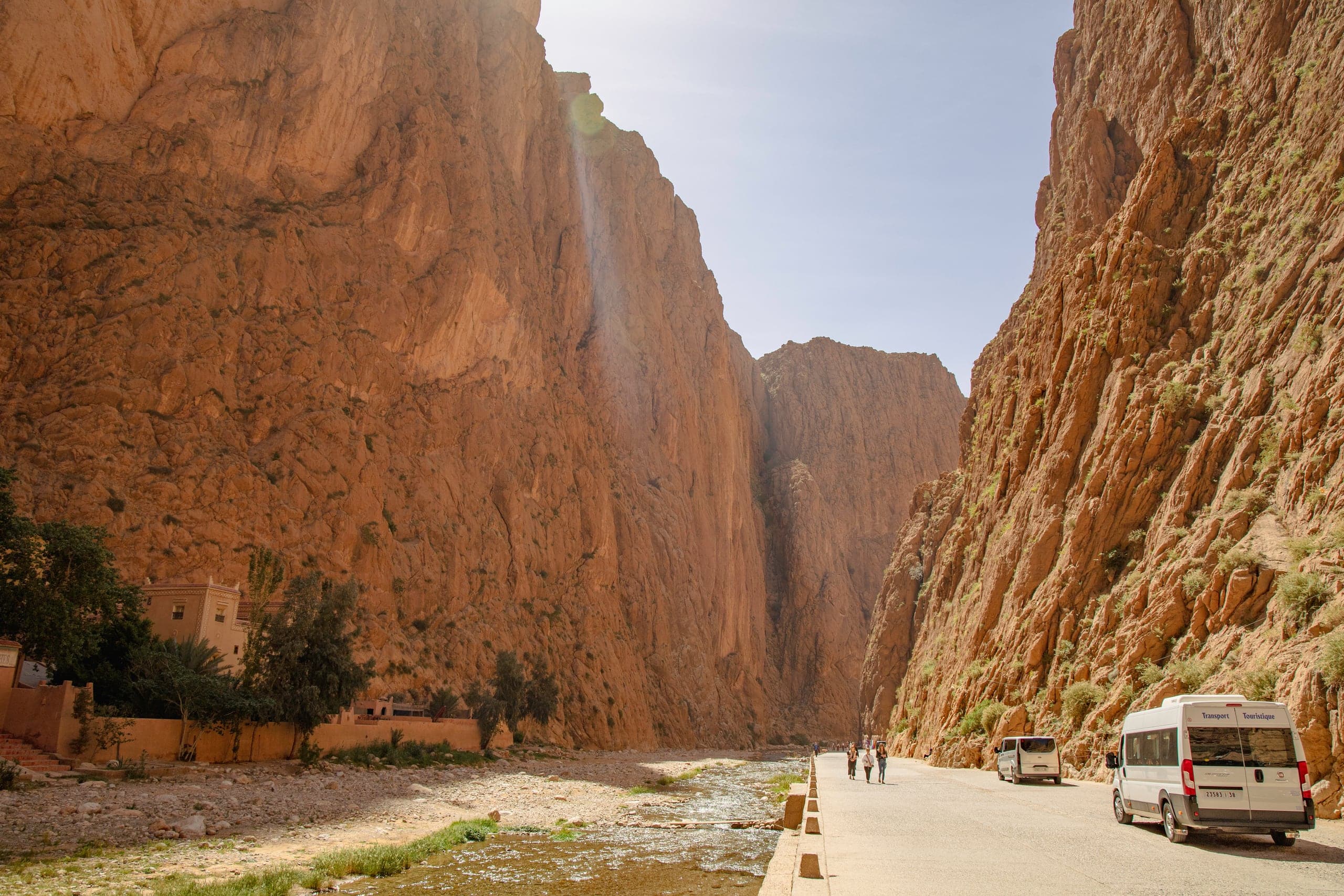 Towering rock walls of the Todra Gorge with a minibus parked below
