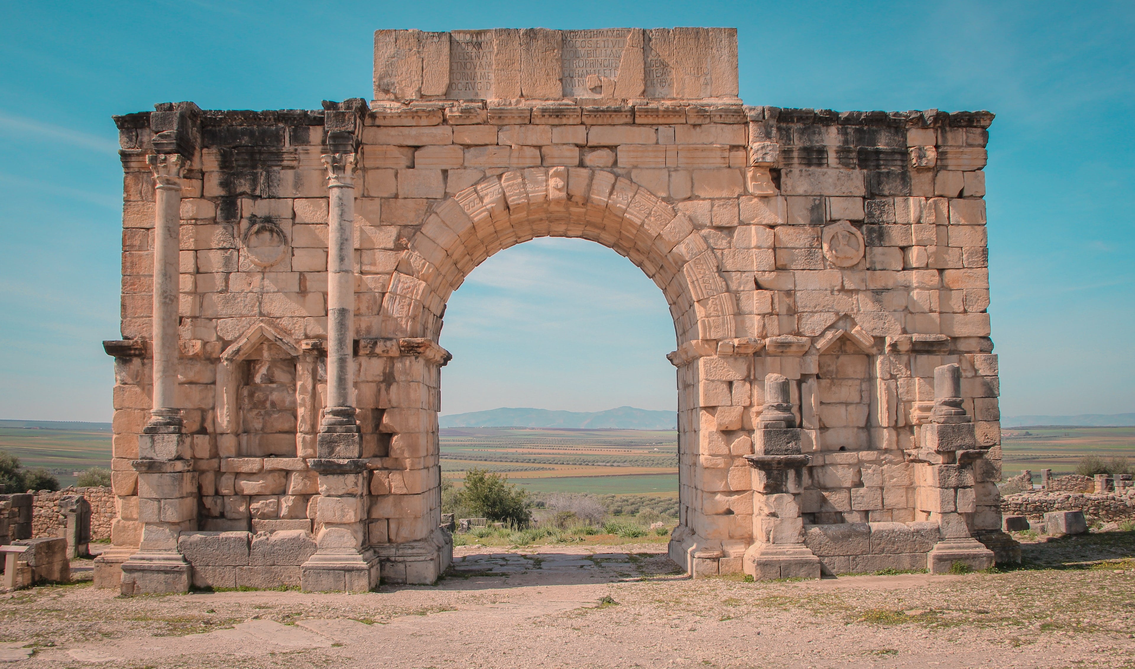 The Roman Arch of Caracalla at Volubilis under a blue sky